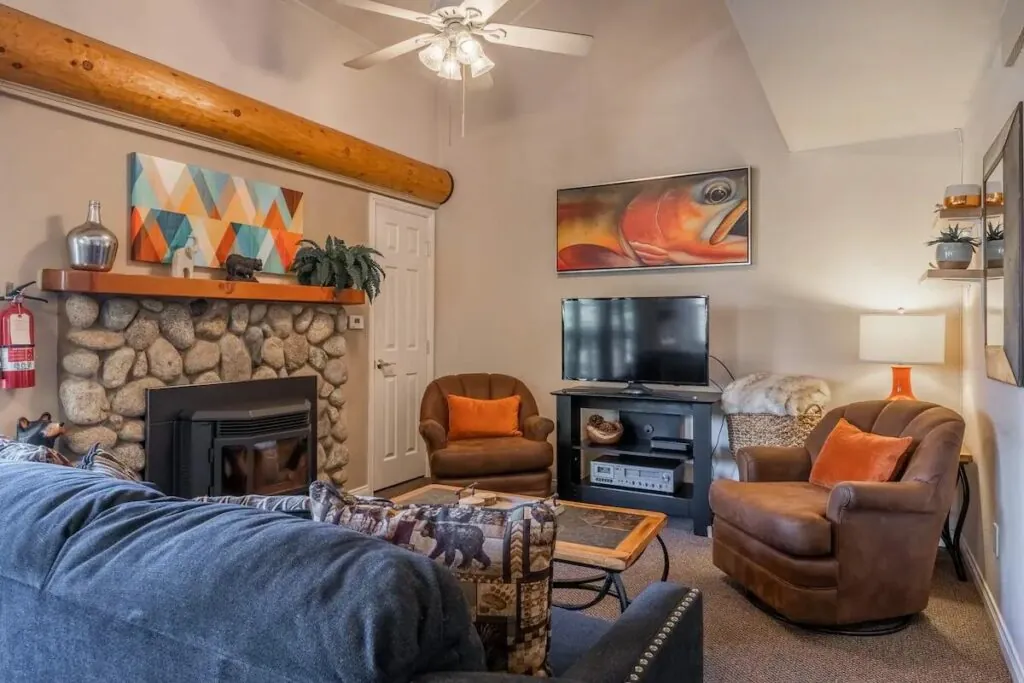 Living room with river rock fireplace in the 1-bedroom + loft Aloha Mammoth condo